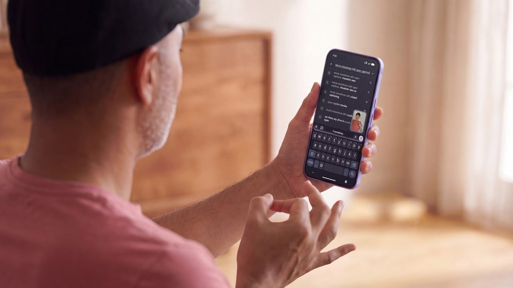 A person signs with one hand while holding a smartphone, demonstrating the Gboard sign-to-text dictation feature.